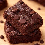 Delicious fudgy Black Bean Brownies served on a plate with cocoa powder and black beans.