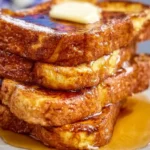 Delicious Blackstone French Toast plated with syrup and berries.