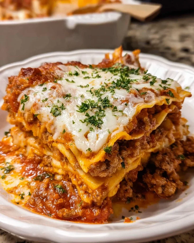 Delicious Crockpot Lasagna served in a dish with melted cheese and layers of pasta.
