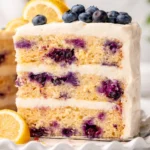 Delicious Lemon Blueberry Cake topped with fresh blueberries and lemon buttercream.